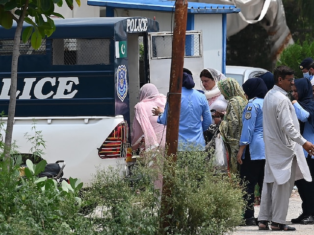 Women police officers taking the arrested female workers of the Pakistan Tehreek-e-Insaf (PTI) from the party's headquarters into police van after a security raid in Islamabad. (Image: AFP)